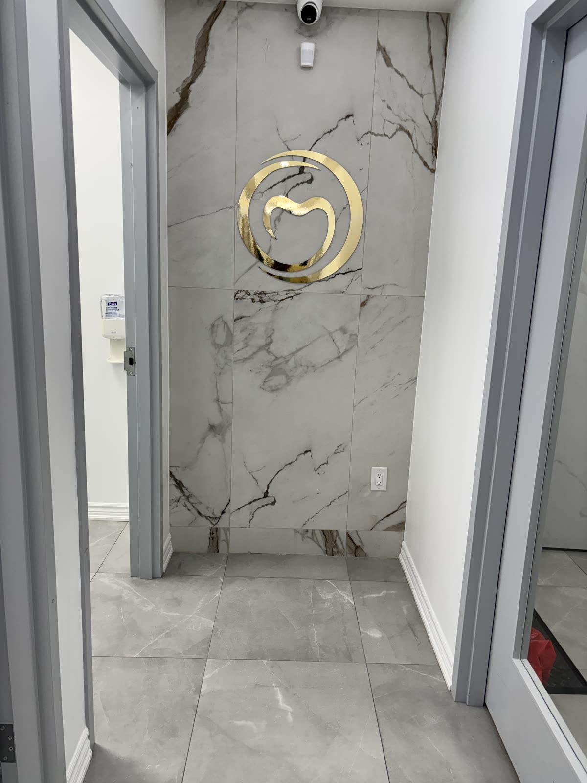 Courtice Family Dentistry logo on a marble feature wall in the practice hallway
