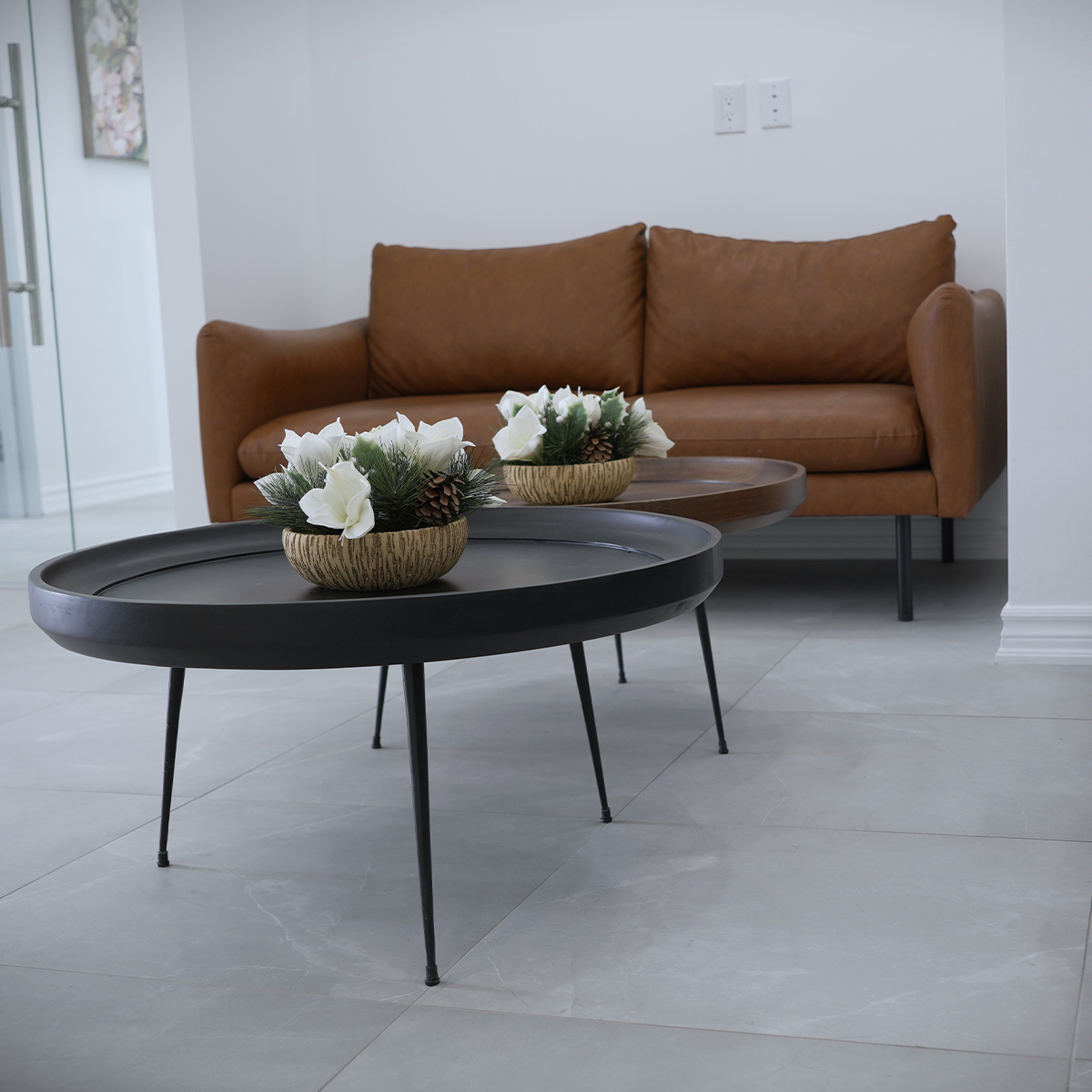 Waiting area with a leather sofa and round coffee tables