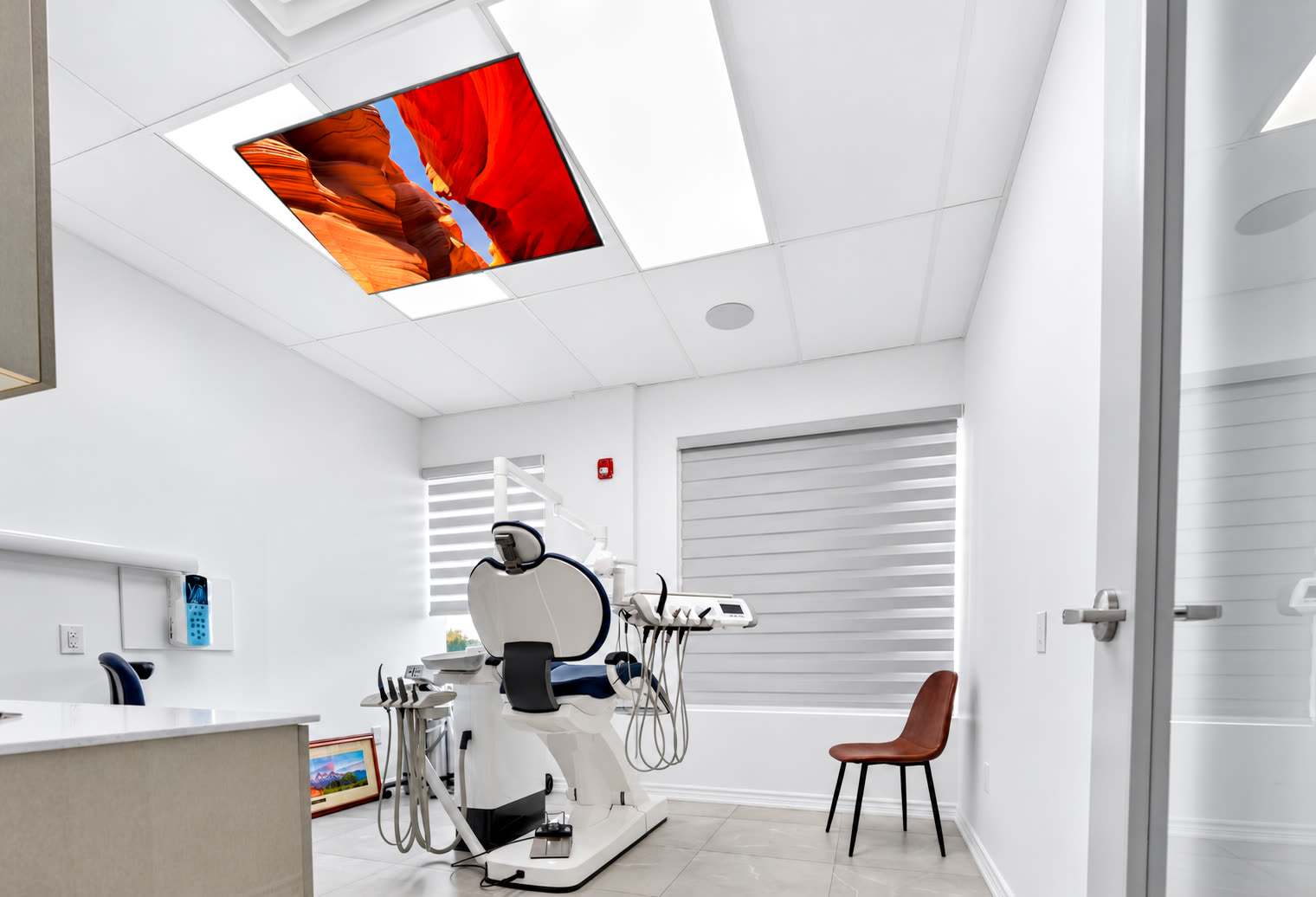 Treatment room with a screen in the ceiling above the dental chair